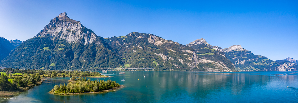 Alpensee mit bewaldeten Bergen und Segelbooten, Sommerlicht, Zentralschweiz, Schweiz – Jan Geerk Fotograf Basel