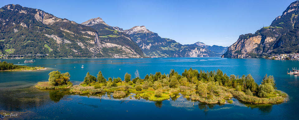 Alpensee mit bewaldeter Insel, Gebirgslandschaft bei Flüelen, Sommerlichtstimmung in der Zentralschweiz – Jan Geerk Fotograf Basel.