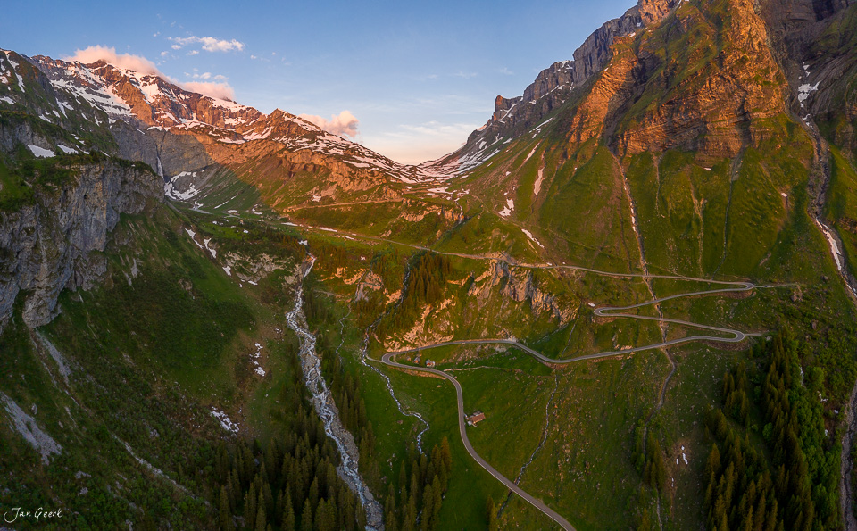 Serpentinenstraße durchs Alpental mit Wasserfall und Bergkulisse, Sommerlichtsimmung Schweiz – Jan Geerk Fotograf Basel