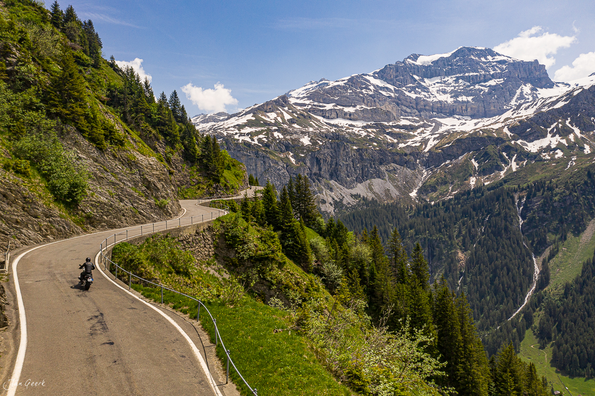 Motorrad auf Serpentinenstrasse am Klausenpass mit Schneebergen Frühling Zentralschweiz Schweiz – Jan Geerk Fotograf Basel