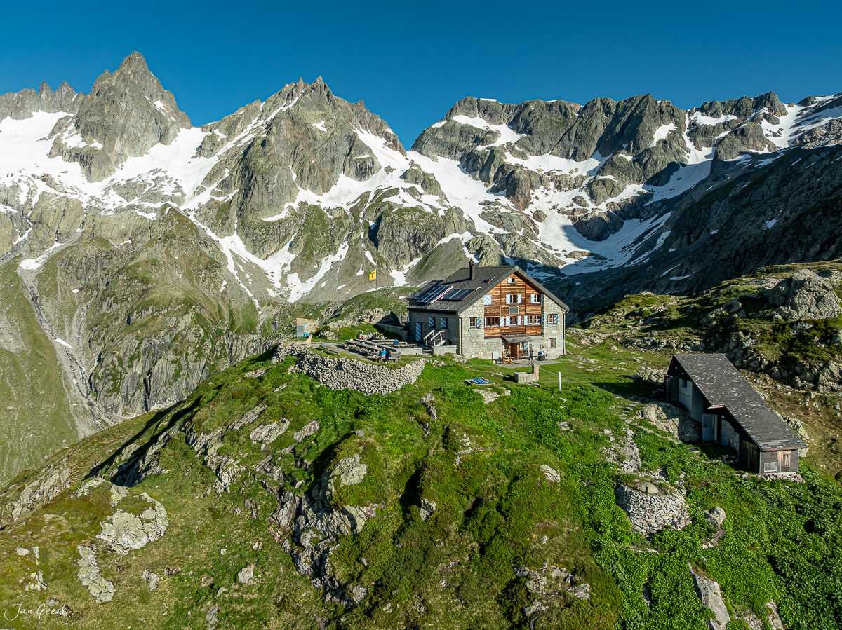 Berghütte am Sustenpass mit schneebedeckten Alpengipfeln im Sommer, Uri, Schweiz – Jan Geerk Fotograf Basel