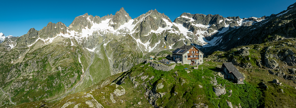Alpenhütte am Sustenpass mit schneebedeckten Bergen im Hintergrund, Sommer, Zentralschweiz Schweiz – Jan Geerk Fotograf Basel