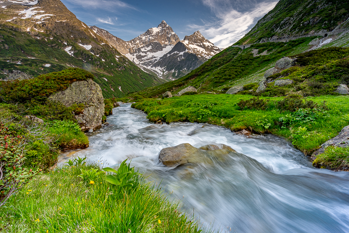 Gebirgsbach am Sustenpass mit schneebedeckten Alpengipfeln, grüne Bergwiesen, Sommer, Uri, Schweiz – Jan Geerk Fotograf Basel