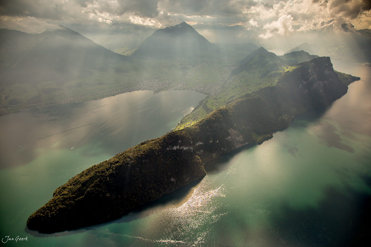 Luftaufnahme der bewaldeten Halbinsel im Vierwaldstättersee mit Bergen in Zentralschweiz – Jan Geerk Fotograf Basel