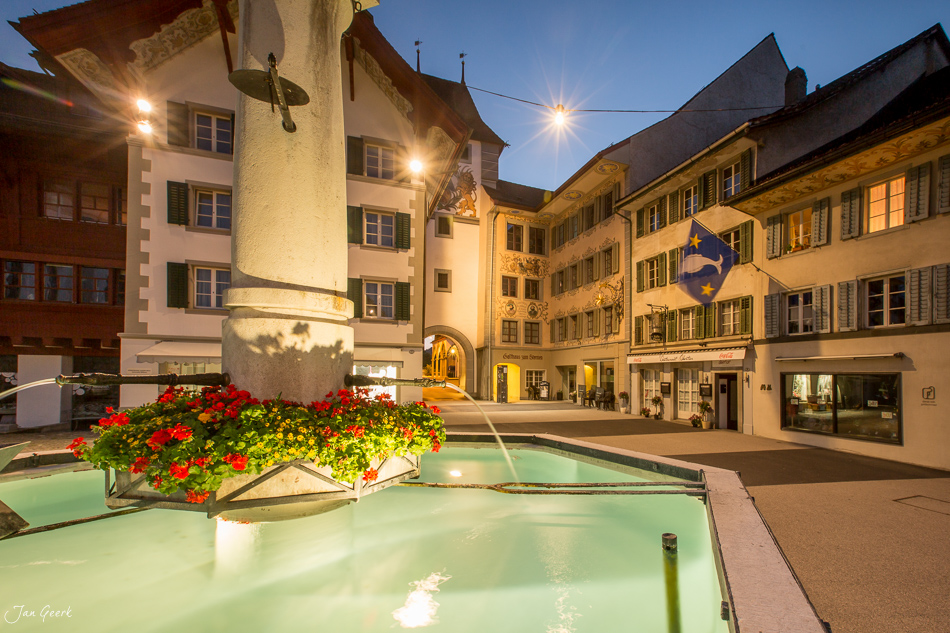 Historische Altstadt Willisau mit beleuchtetem Turm und roten Blumenkübeln am Abend, Zentralschweiz Schweiz – Jan Geerk Fotograf Basel