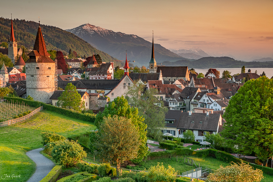 Malerische Altstadt Zug mit Kirchtürmen, See und schneebedeckten Bergen im goldenen Herbstlicht – Schweiz Jan Geerk Fotograf Basel