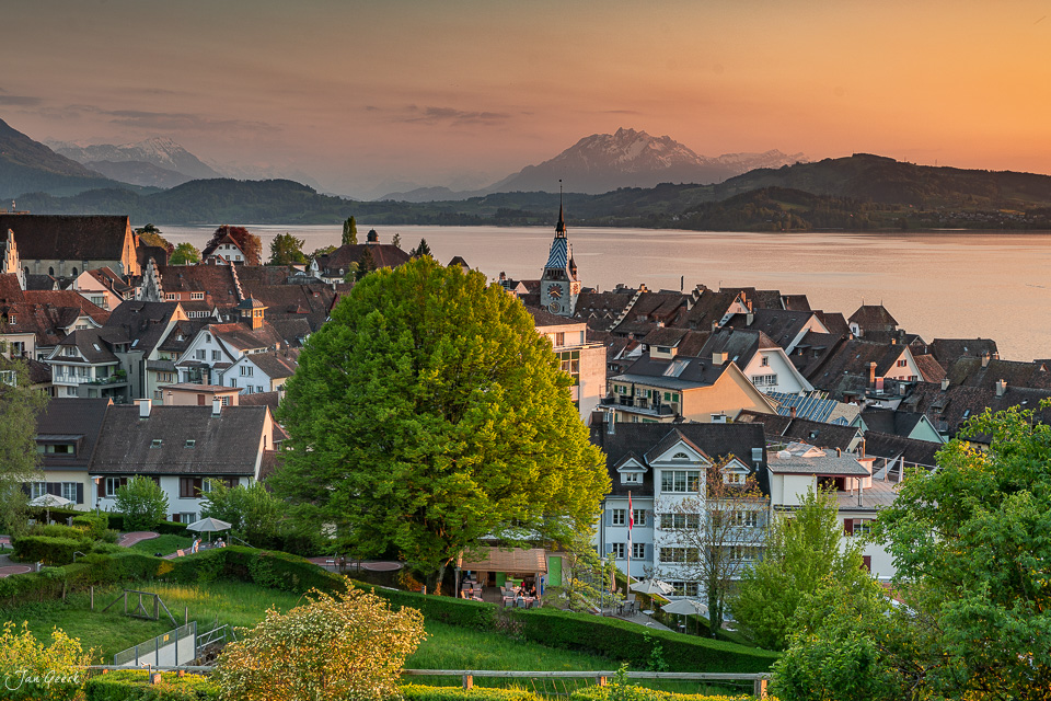 Malerische Altstadt Zug mit Kirchtürmen am Zugersee, schneebedeckte Berge Pilatus und Rigi im Hintergrund, goldene Stunde, Zentralschweiz – Jan Geerk Fotograf Basel