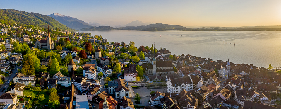 Luftaufnahme der Stadt Zug am See mit Bergen im Frühling, Zentralschweiz – Jan Geerk Fotograf Basel