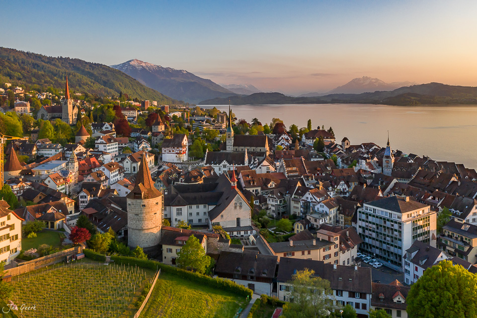 Luftaufnahme der Altstadt Zug am See mit Kirchtürmen, Bergen und Frühlingslicht, Zentralschweiz – Jan Geerk Fotograf Basel
