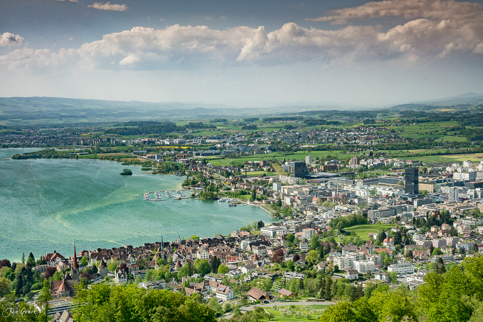 Luftaufnahme der Stadt Zug mit Zugersee im Frühling, grüne Landschaft und Kantlicht, Zentralschweiz – Jan Geerk Fotograf Basel