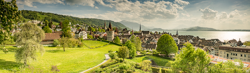 Altstadt Zug im Frühling mit Zugersee, grüne Wiesen und historische Kirchtürme, Schweiz – Jan Geerk Fotograf Basel