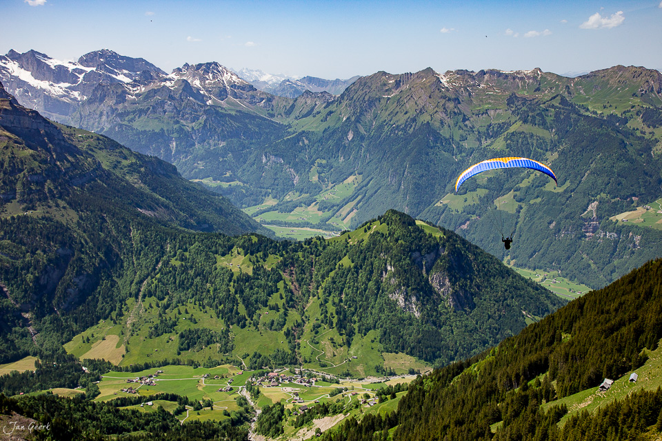 Paraglider über Seebodenalp mit Blick auf Pilatus und Alpental bei sommerlichem Wetter in der Zentralschweiz – Jan Geerk Fotograf Basel