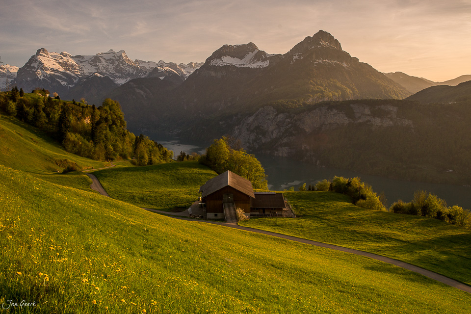 Alpenhütte in Morschach mit Blick auf schneebedeckte Berge und See, Frühjahrslichtstimmung Zentralschweiz Schweiz – Jan Geerk Fotograf Basel