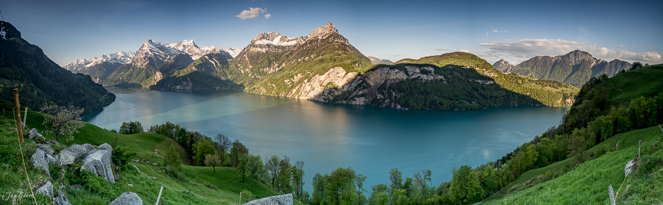 Bergpanorama mit türkisblauem See, grünen Alpweiden und schneebedeckten Gipfeln bei Morschach im Frühling – Zentralschweiz Fotografie von Jan Geerk Basel