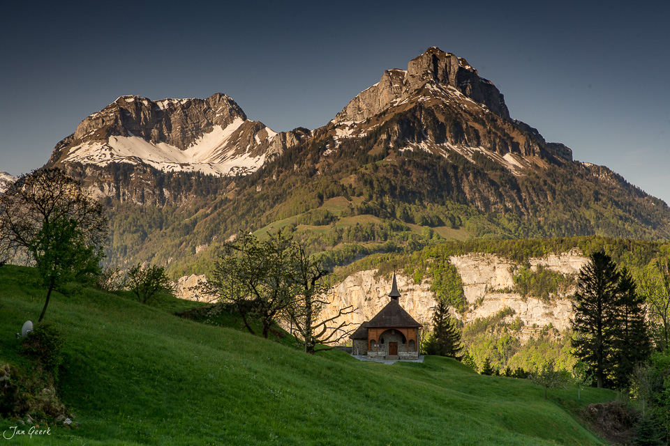 Kleine Kapelle in Morschach mit majestätischen Bergen im Frühling, Zentralschweiz – Jan Geerk Fotograf Basel