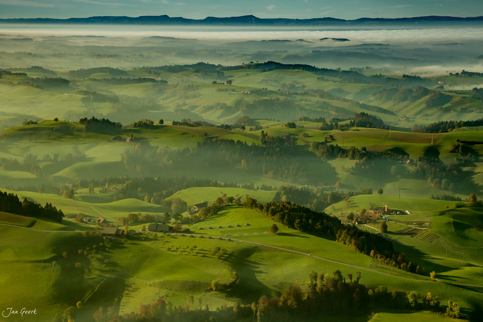 Herbstliche Hügellandschaft Napfgebiet mit Nebel, Wiesen und verstreuten Höfen in der Zentralschweiz – Jan Geerk Fotograf Basel