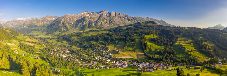 Luftaufnahme des Dorfes Sörenberg mit grünen Alpwiesen, Bergen und Sommerlight in der Schweiz – Jan Geerk Fotograf Basel