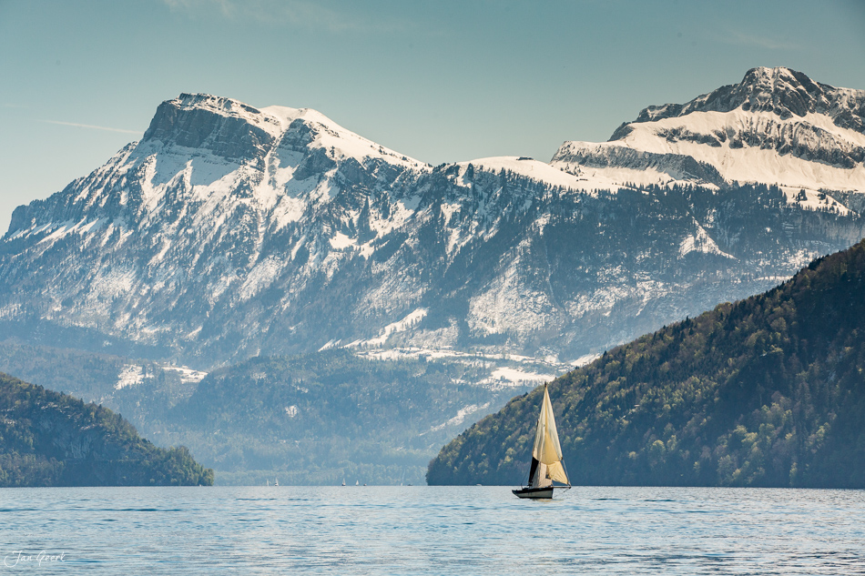 Segelboot auf dem Vierwaldstättersee mit verschneiten Bergen Pilatus und Rigi im Frühling, Zentralschweiz – Jan Geerk Fotograf Basel