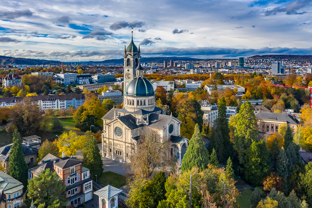 Kirche mit Herbstfarben in Zürich, Luftaufnahme mit Alpen und See, Herbststimmung Schweiz – Jan Geerk Fotograf Basel