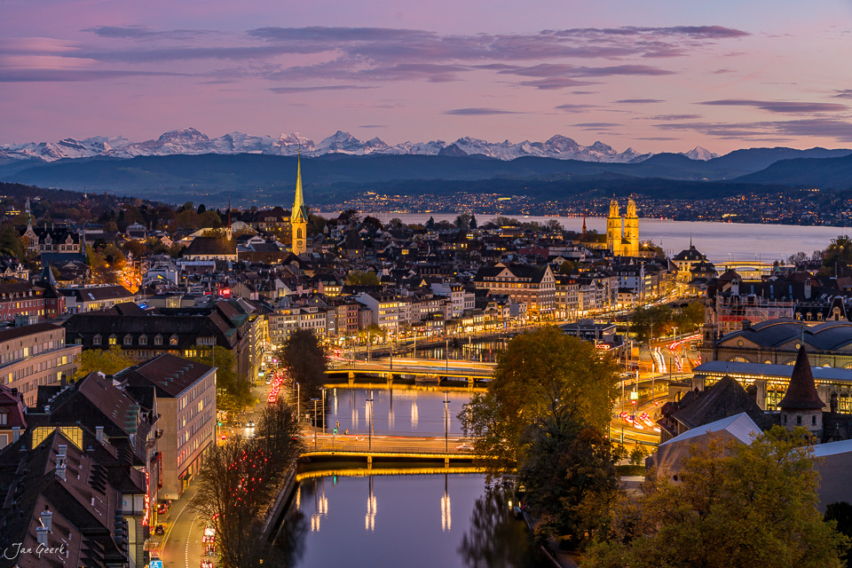 Zürich Skyline mit Fraumünster und Grossmünster, Limmat und Alpenblick bei Sonnenuntergang, Herbst in der Schweiz – Jan Geerk Fotograf Basel
