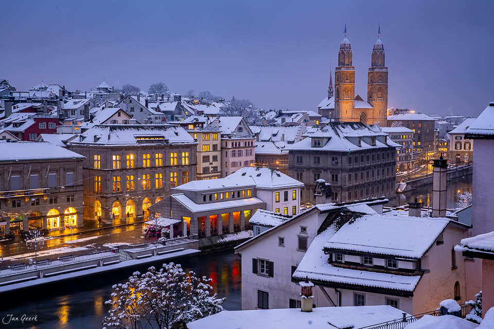 Winterliche Altstadt Zürich mit schneebedeckten Dächern und beleuchteten Gebäuden, Grossmünster bei Dämmerung, Schweiz – Jan Geerk Fotograf Basel