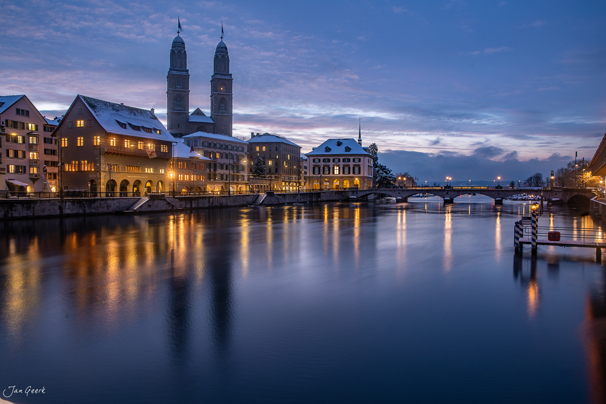 Grossmünster und Fraumünster spiegeln sich im winterlichen Wasser der Limmat in Zürich bei Nacht – Jan Geerk Fotograf Basel Schweiz